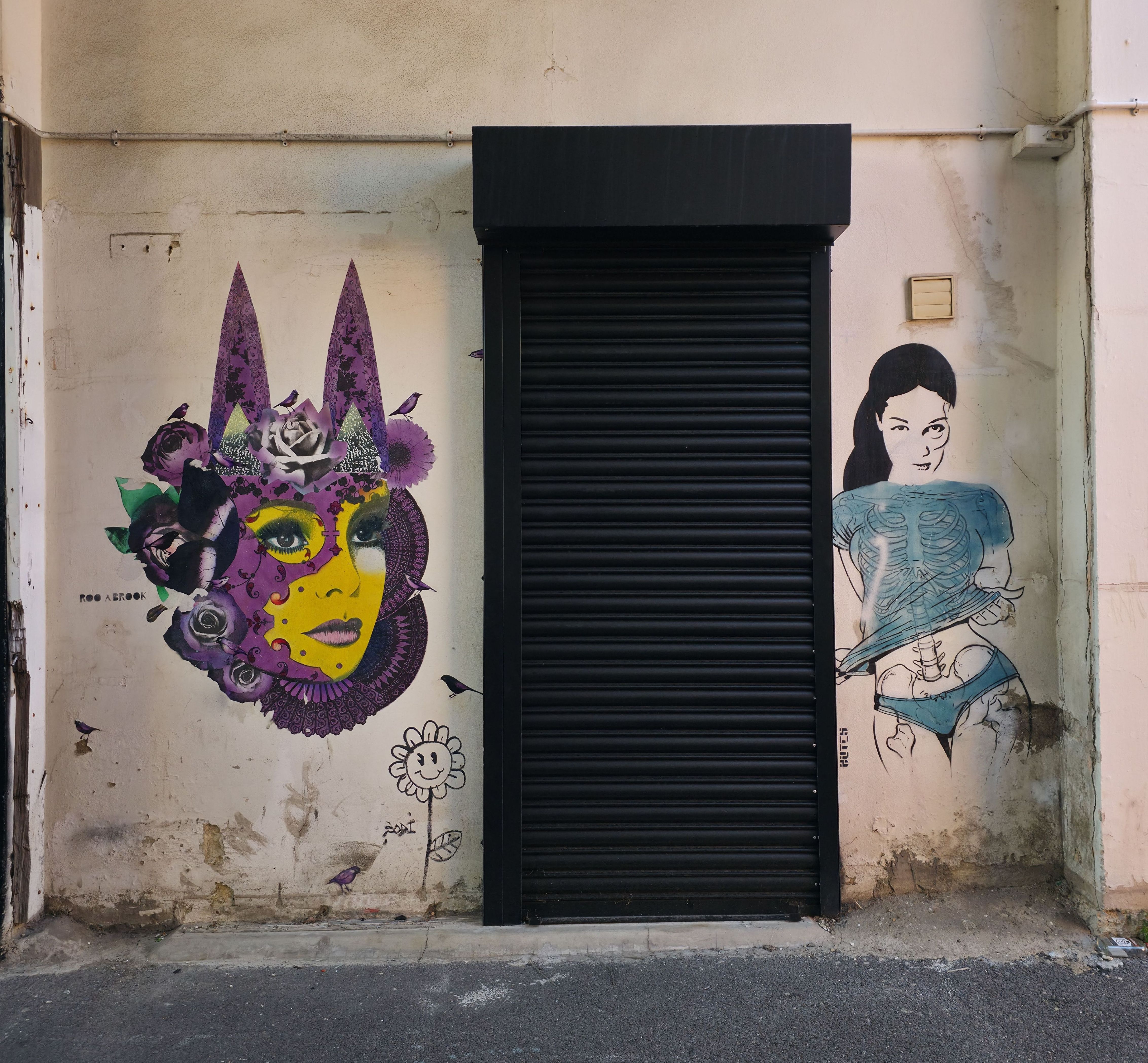 Photo of a purple Jester type face, and a lady in blue ink with black hair, found in Albert Road, Southsea, Hampshire, United Kingdom. Photo taken by Baldi, A.K.A Amonn AL-Mahrouq.
