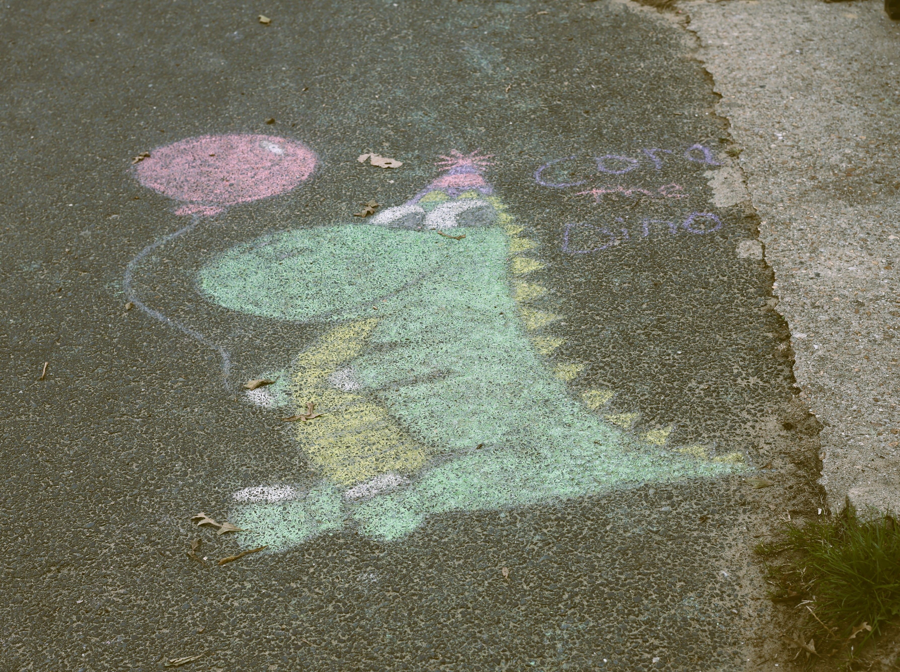 Photo of Street Art found in Ryde, Isle of Wight depicting a sea coloured Dragon holding a purple balloon. Photo taken in September 2026 by Baldi, A.K.A Amonn AL-Mahrouq.