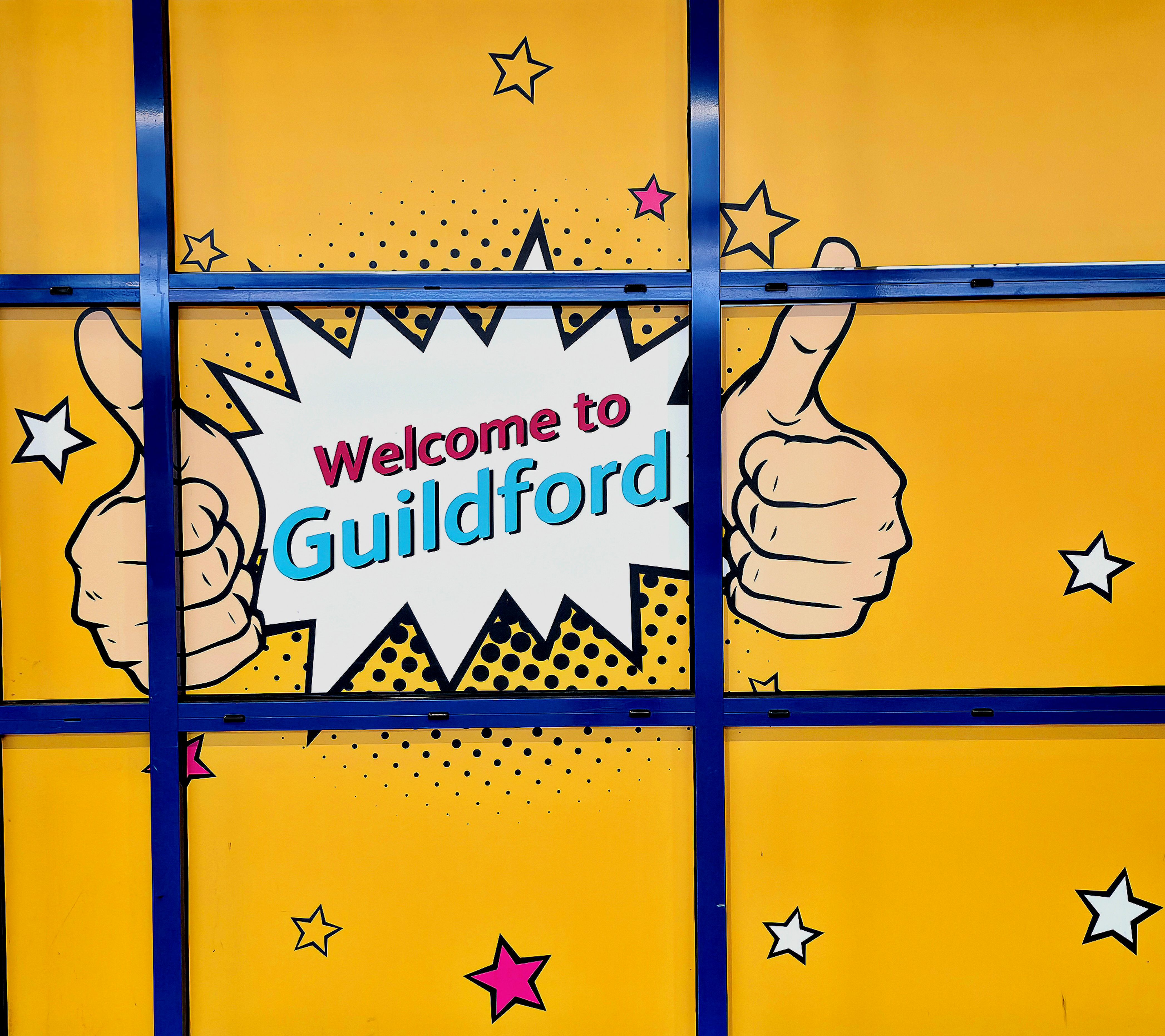 A photo a yellow fun sign welcoming your to Guildford, Surrey, United Kingdom. Photo taken on March 20, 2026 by Baldi, A.K.A Amonn AL-Mahrouq
